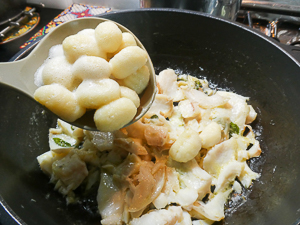 aggiungere gli gnocchi al condimento di pesce