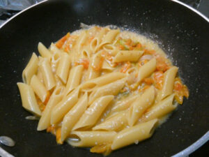 mantecare la pasta con salsa di pomodorini e fiori di zucca