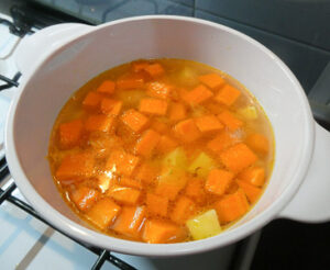 aggiungere brodo a carote e patate