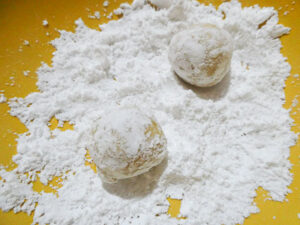 ricoprire le palline di impasto con zucchero a velo
