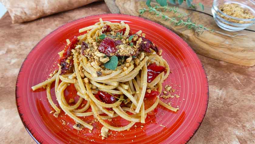 spaghetti con peperoni cornetto e granella di nocciole
