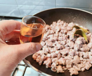 aggiungere il brandy per rosolare la salsiccia in padella