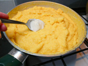 sugna e formaggio aggiunti alla polenta