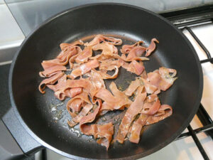 saltare le fette di prosciutto in padella