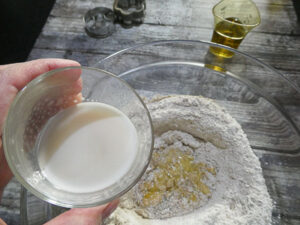 unire uovo, olio, latte e lievito alla farina