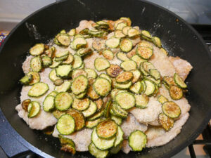 mettere zucchine e parmigiano sulle fette di maiale