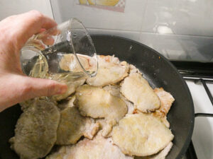 sfumare le fette di maiale con vino bianco